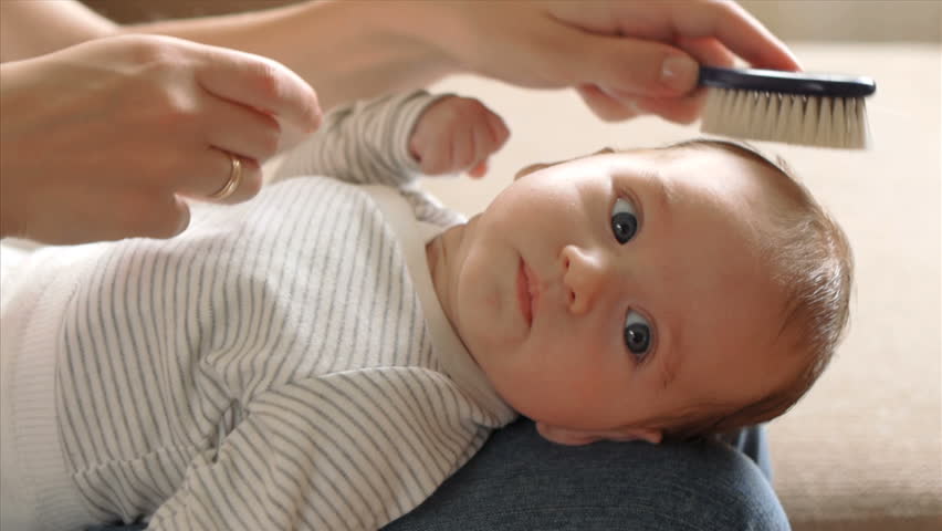 Mother combing her baby's hair