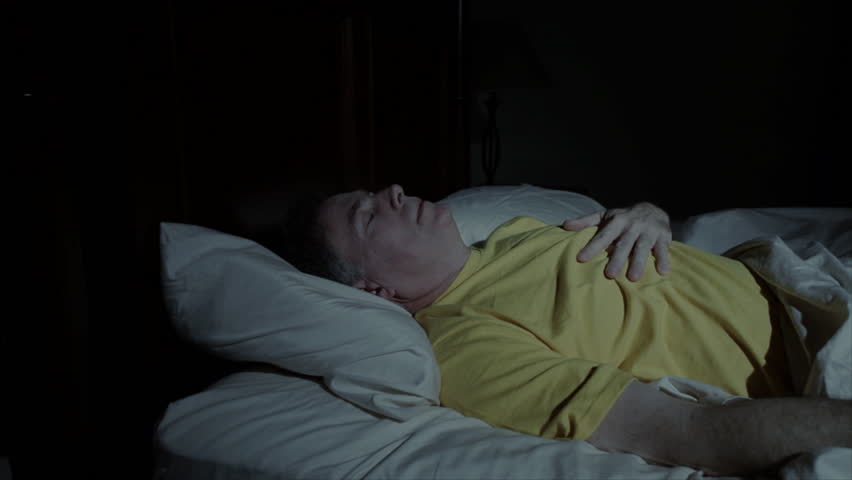A mature man  is awakened by heartburn