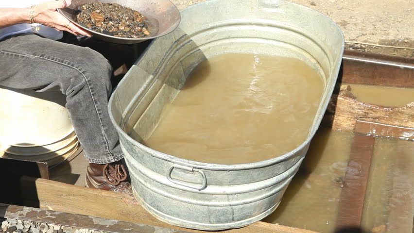 Gold panning demonstration at a tourist destination in Fairbanks, Alaska. Woman shows how to pan for gold. 