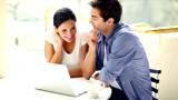 Relaxed young couple sitting together working on a laptop 