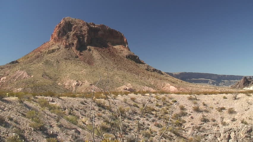 Camera pans showing the mountains rocky side to the entire landscape