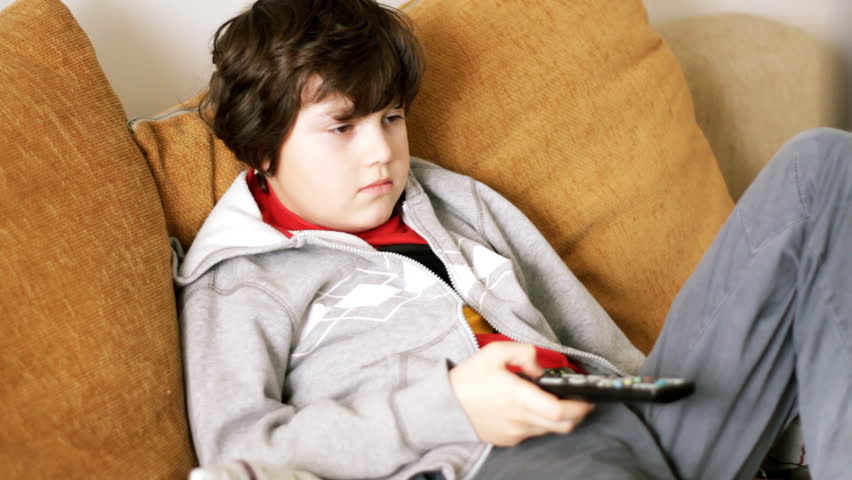Young bored boy watching tv