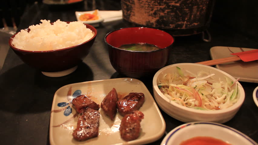 Eating delicious Japanese Barbecue Steak with sauce, Soya, Miso Soup, Pickles and rice at a restaurant in Tokyo, Japan