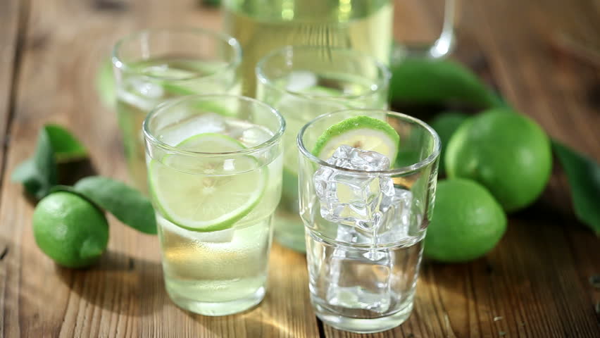 filling up glasses with fresh lemon juice on rustic table outdoors