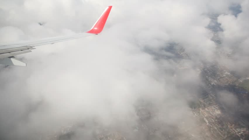 vision of cumulus clouds above London city from airplane flying high over it