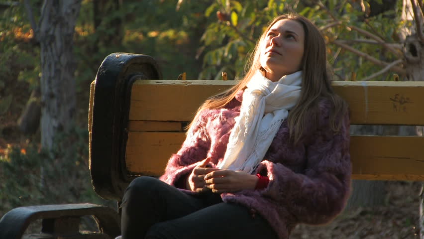 Thoughtful Young Girl Sitting on Bench 