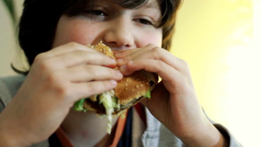 Young boy eating hamburger 