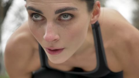 Young motivated girl is preparing to run in park in summer, heathy lifestyle, sport conception