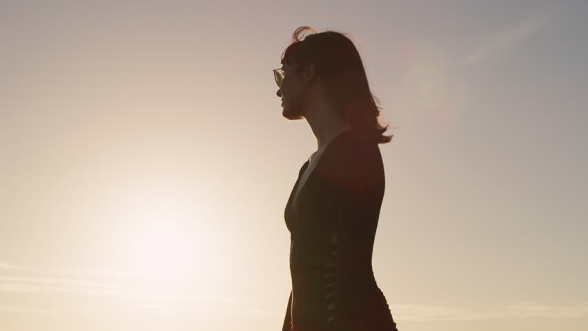 Close up of beautiful girl walking along beach at sunset. Shot with a RED camera. 4k footage.