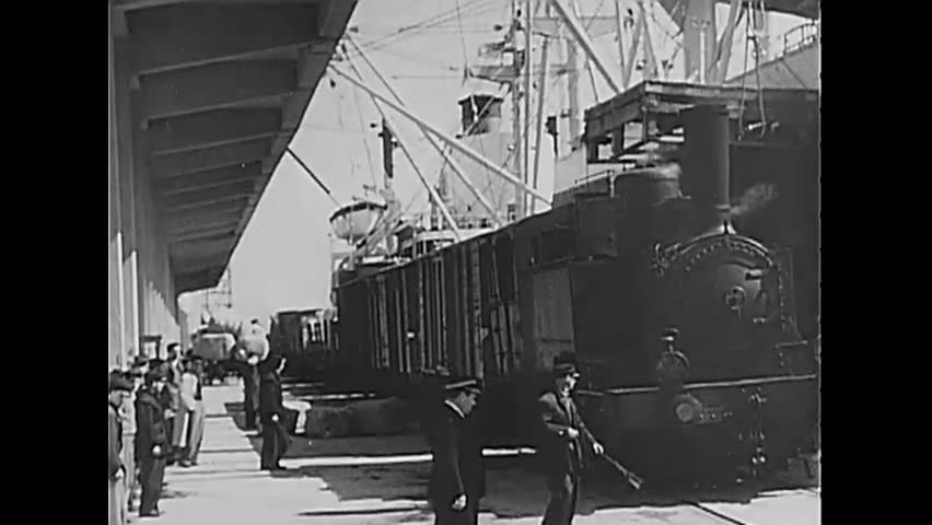 circa 1950 a train pulls out of a station and moves along the italian countryside guards open a padlocked gate for it to enter frieght conductor