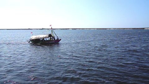 Jakarta 18 April 2019 Traditional Passenger Boat With Indonesian National Flag Crossing Or Sailing The Beach Or Sea At Taman Impian Jaya Ancol Kid At Ship Hull Is Dancing In Happiness