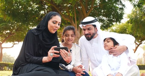 Happy muslim family spending weekend time at the park in dubai