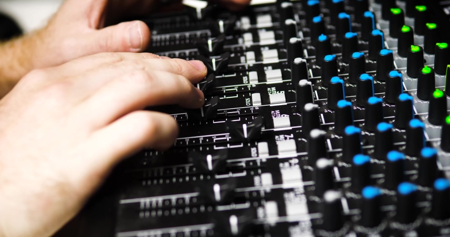 av technician fine tuning sound mixer board audio levels audio visual technician