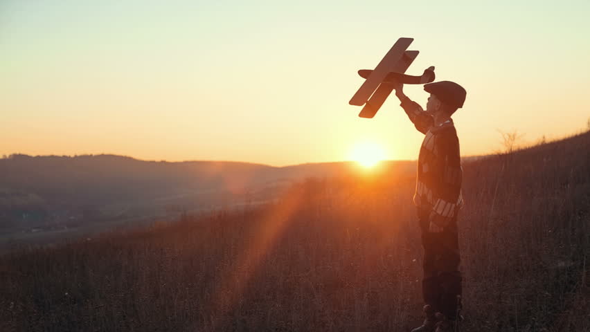 Happy Kid Playing With Toy Airplane Against Orange Sun Summer Sky ...