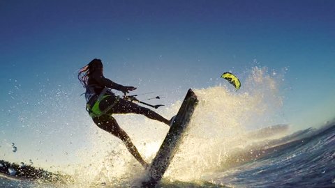 Extreme Kitesurfing at Sunset. Summer Ocean Sport in Slow Motion. Girl Kite Surfing in Bikini