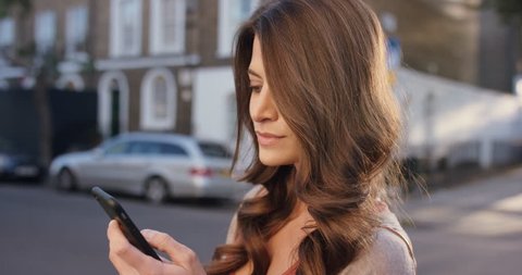 Beautiful woman using smart phone technology app in city streets living urban happy lifestyle