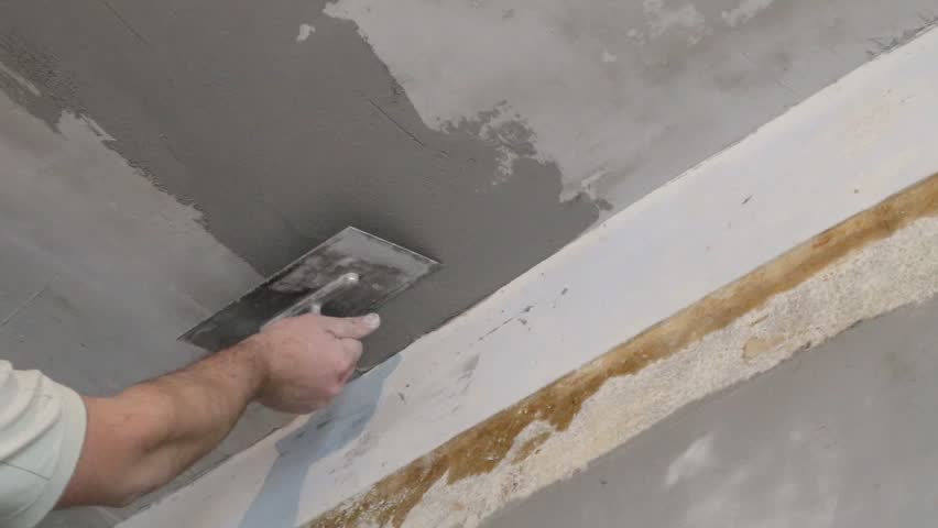 Builders Hand With Float Aligns The Ceiling With Plaster