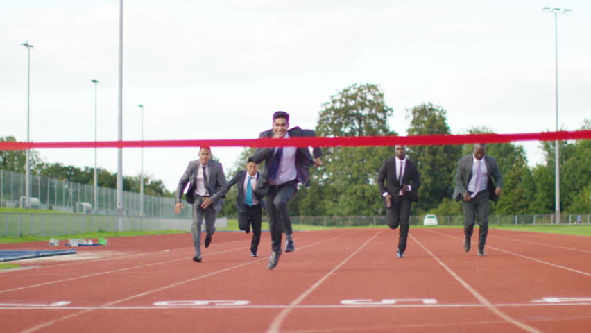 Businessmen in suits on a race track.