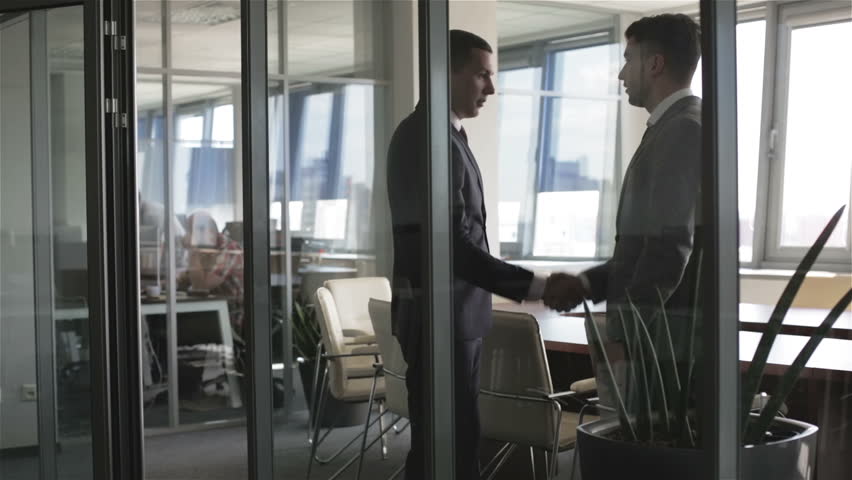 Ufa Russia 05 06 2017 People Enter Into Rotating Spinning Two Businessmen Meet And Shake Hands In A Meeting Room Business People Is Sitting Down