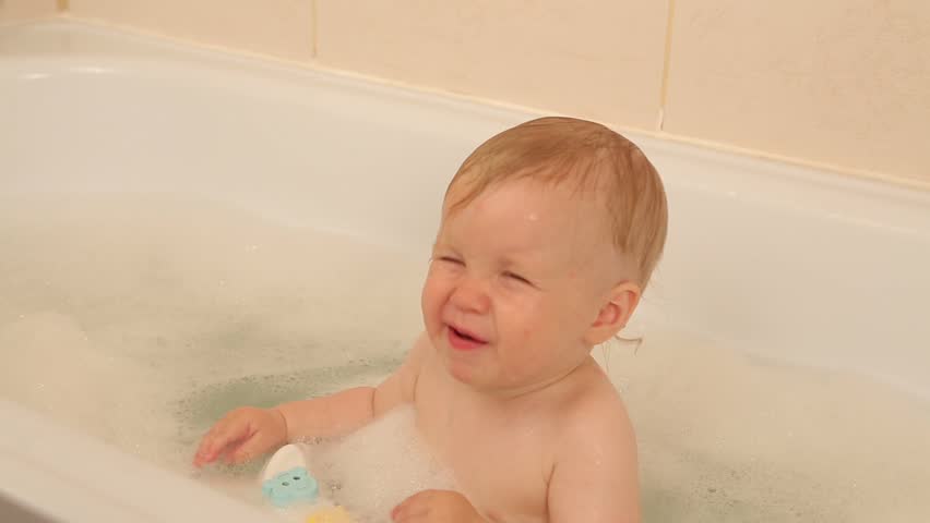 Nine Month Old Baby Having A Bath With Mom In Bathtub Indoor Baby Smiles And Laughs When He Playing With Toys In A White Bubble Bath Caucasian
