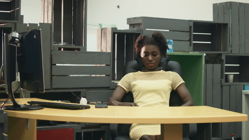 Person At Work During The Evening Under Desk Lamp Looking African Female Worker In Office Chair After Workday Using Gles Of Virtual Reality Hd Stock