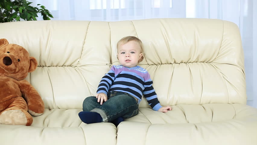 Smiling Baby Boy Sitting On The Couch