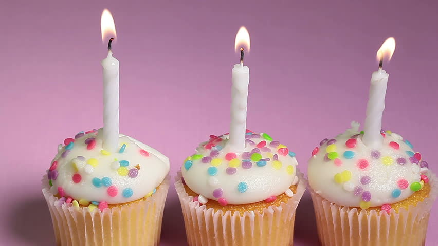 Hd0008three Vanilla Birthday Cupcakes With Lit Candles Being Blown