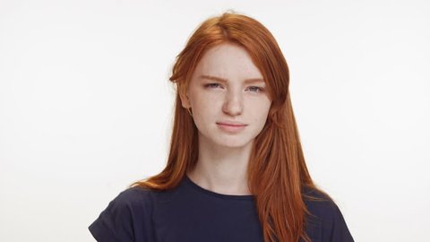 Surprised cute teenage foxy caucasian girl standing on white background  raising eyebrows