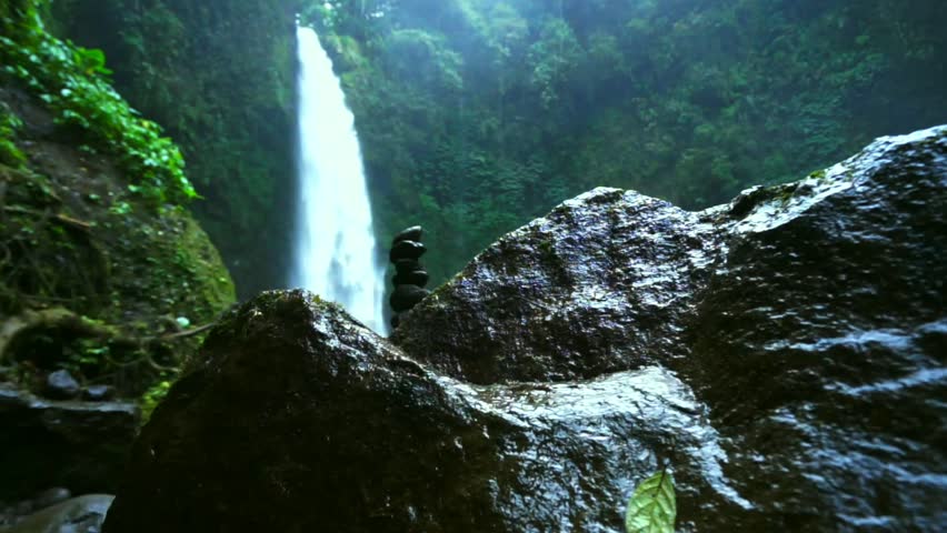 Amazing Nungnung Waterfall Falling Water Stock Footage 100 Amazing Nungnung Waterfall Falling Water Hitting Surface Some Huge Rocks Seeable In Front Of Frame Lush Green Leafes Is Moving From The Wind Bali
