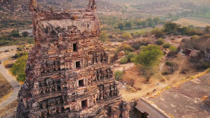 Flight over Sri Hanuman temple, Hampi, Karnataka, India. Amazing flinstones -like hills in the background