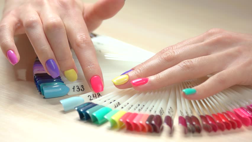 Multi Colored Nails multicolored manicure and nail polish samples young woman well groomed hands with pastel summer manicure choosing nail color in beauty salon