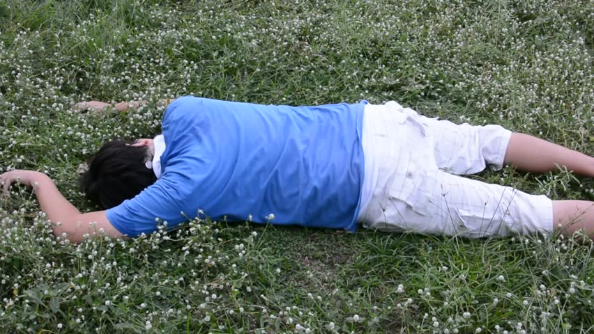 An Asian Thai man drop dead on the grassy ground field and twitching in ...