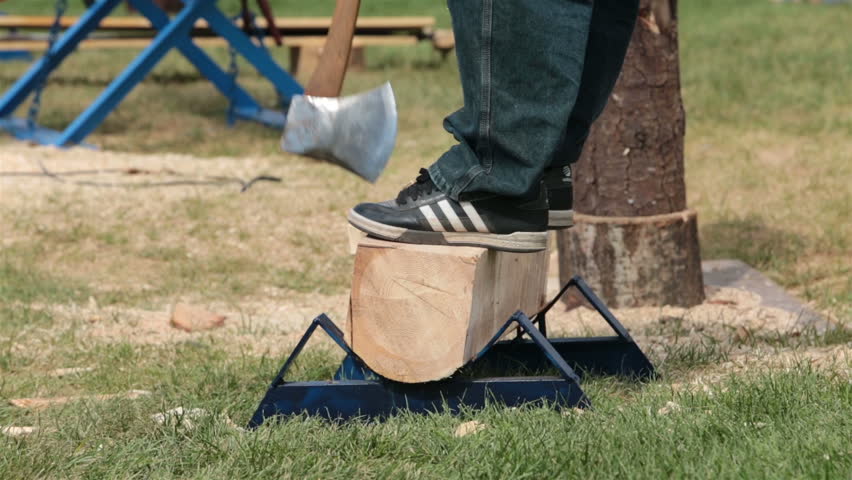 Lumberjack Cutting  Log  With Axe Between Feet A Lumberjack 