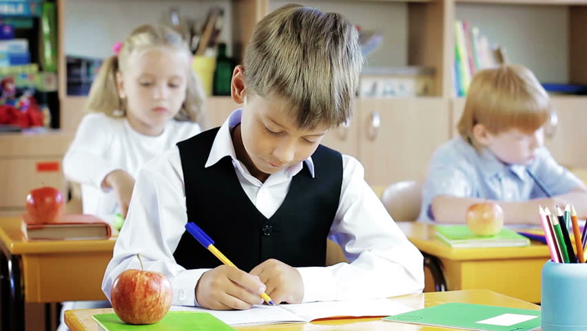 Hd00 09little Schoolboy Sitting Behind School Desk During Lesson In