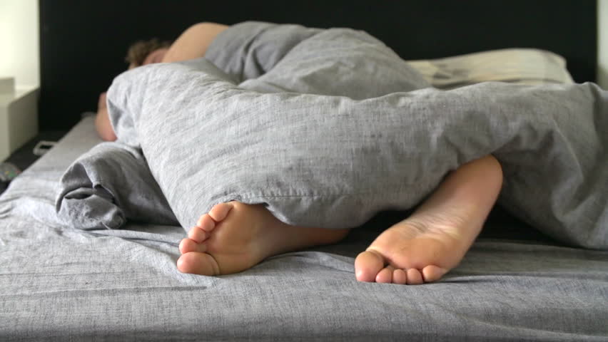 Stock Video Clip of Teenage boy's feet poking out of the | Shutterstock