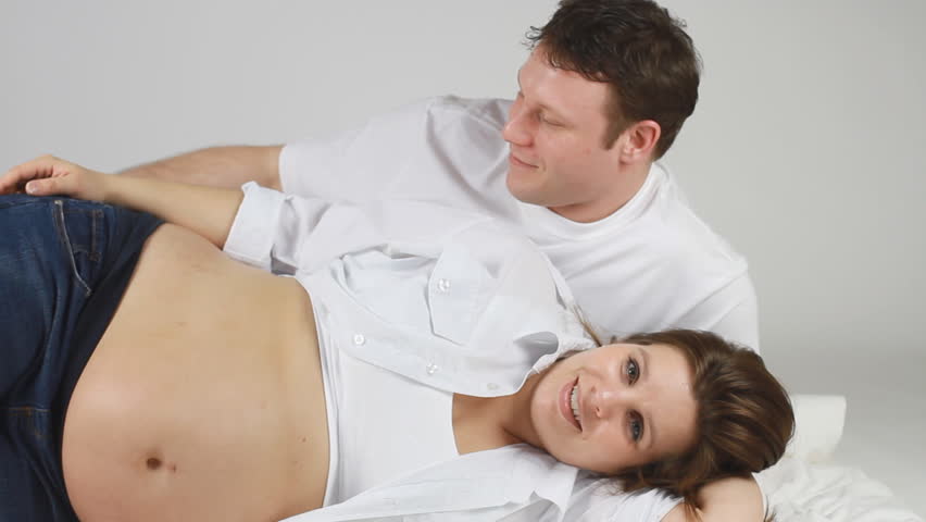Dad Rubbing The Stomach Of His Pregnant Wife While Lying ...