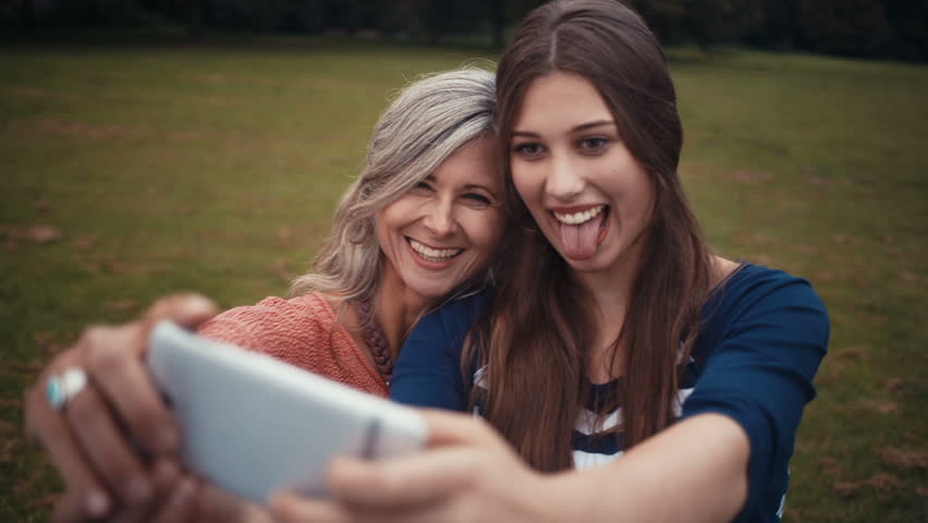 Mother And Daughter Pose Together For A Selfie With Their Smart Phone Mother And Daughter Pose Together For A Selfie With Their Smart Phone