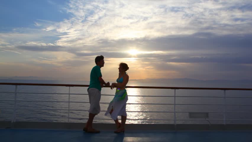 Young Couple Stands On Deck Of Cruise Ship And Talks Against Sunset Sky ...