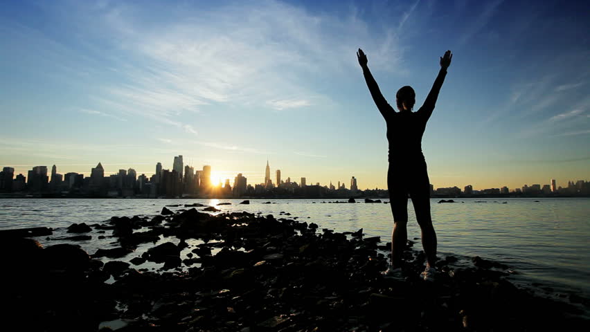 Female Practicing Yoga Exercises At Sunrise With A City Skyline ...